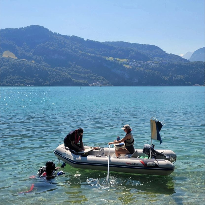 Das Tauchteam bereitet sich auf den Tauchgang vor: Die Kamera wird geprüft, das wasserfeste Erhebungsblatt wird auf dem Boot fertig beschriftet und die Bootsführerin bereitet die GPS-Boje vor. Die blau-weisse Flagge am Boot zeigt an, dass sich Tauchende im Wasser befinden.